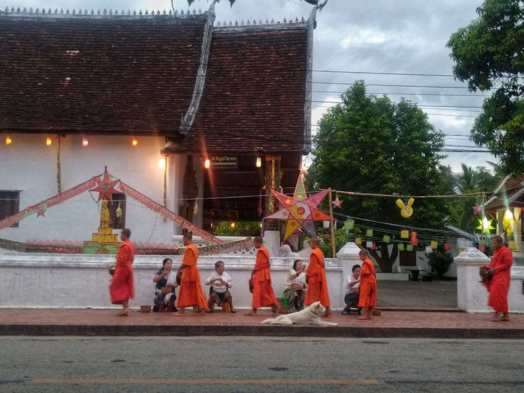 Luang Prabang Monks walking down the street receiving alms Sai Bat